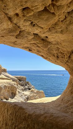 the view from inside a cave looking out at the ocean