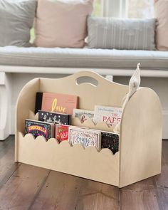 a wooden book holder filled with books on top of a hard wood floor