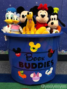 several stuffed animals in a blue bucket with the words book buddies written on it and mickey mouse