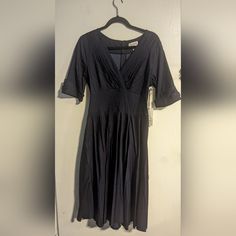 Nwt. Unique Vintage Denim Blue Delores A-Line Swing Dress. It Has A V-Neckline With Half Sleeves And Buttons At The Ends. It Is Super Stretchy With A Back Zipper. There Is A Reference Picture To See It On. B:38-39",W:31-32.5", H:42-44". The Skirt Sits A Little Below The Knee. Elegant Short Sleeve Denim Dress, V-neck Denim Dress For Work, Spring V-neck Denim Dress For Work, Spring Workwear V-neck Denim Dress, Blue V-neck Denim Dress For Work, Dark Wash Knee-length Denim Dress With Buttons, Knee-length Dark Wash Dress With Button Closure, Dark Wash Knee-length Dress With Button Closure, Dark Wash Denim V-neck Dress With Pockets