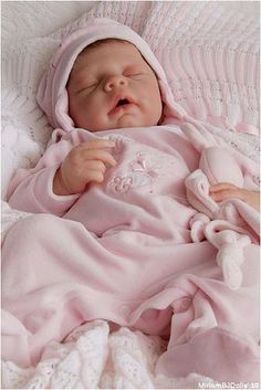 a baby is sleeping on a pink blanket