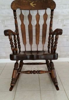 a wooden rocking chair with an arrow on the back and arms, in front of a white brick wall