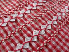 red and white gingham fabric with small hearts on it's side, close up