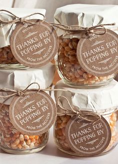 some jars filled with beans and brown paper tags on top of each jar are labeled thanks for popping