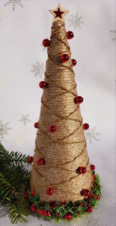 a christmas tree made out of twine wrapped in burlocks and red beads