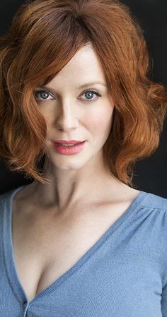 a woman with red hair is posing for the camera