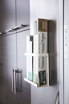 three books are stacked on the wall in front of some cupboards with doors open