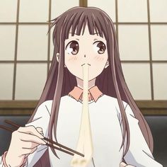 a girl with long hair holding chopsticks in front of her face