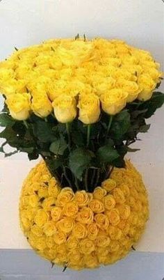 a vase filled with yellow roses on top of a table