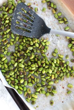 a spatula scooping pistachios out of a pan