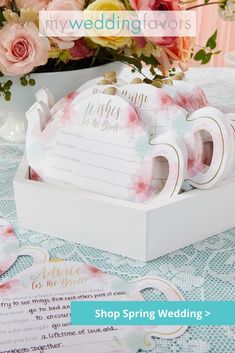 wedding stationery with pink flowers and ribbons in a white box on a blue tablecloth