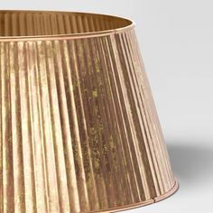 a gold pleated lamp shade on a white background