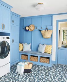 a laundry room with blue cabinets and patterned flooring is featured in this image, along with a washer and dryer