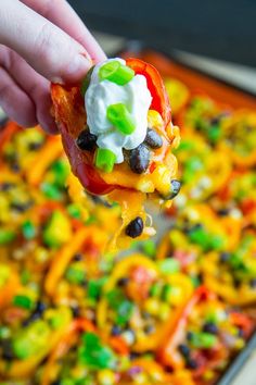 a spoon full of food that is being held up to show the toppings on it