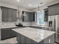 a large kitchen with granite counter tops and stainless steel appliances