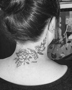 a woman's neck tattoo with flowers on it