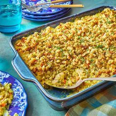 a casserole dish with meat and vegetables in it on a blue table cloth