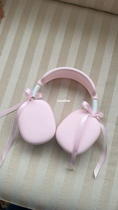 a pair of pink headphones sitting on top of a bed