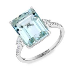 an aqua blue topazte and diamond ring with white diamonds on the sides, set in