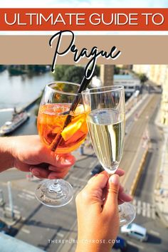 two people toasting with champagne glasses in front of a river and cityscape