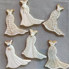 decorated cookies in the shape of brides dresses