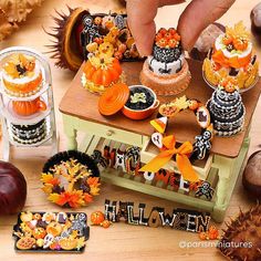 an assortment of halloween decorations on a table with pumpkins and other autumn items around it