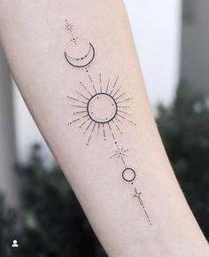 a woman's arm with a sun and moon tattoo on it