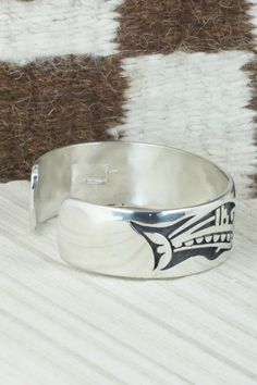 This sterling silver bracelet was made by Hopi silversmith Timothy Mowa. The inside is signed and stamped sterling.Size: 5 3/4" (will fit up to a 6 1/4" wrist)Gap: 3/4"Width: 3/4"Free shipping on all orders! We ship with USPS and always include tracking. All orders ship within a day of payment.Returns are accepted up to 30 days after you receive your order. Just send us a message. Our shop offers cash back or store credit. The item must be returned in new condition. Sterling Silver Collectible Bangle, Etched Sterling Silver Bracelet For Formal Occasions, Formal Etched Sterling Silver Bracelet, Symbolic Engraved Sterling Silver Cuff Bracelet, Unique Etched Sterling Silver Adjustable Bracelet, Unique Etched Adjustable Sterling Silver Bracelet, Unique Engraved Adjustable Sterling Silver Bracelet, Unique Adjustable Etched Sterling Silver Bracelet, Unique Adjustable Engraved Sterling Silver Bracelet