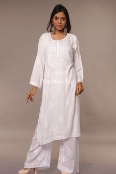 "Nibs Tog White Modal Cotton Chikankari Kurta Set with Dupatta A white attire is must have in Chikankari and adding up this beautiful Chikankari Hand Embroidered All White Kurta palazzo set in pure Modal Cotton Fabric, super soft & comfortable for this summer. Get more details below. Features: Fabric: The Lucknowi Chikankari Kurta for women is made of Pure Modal Cotton, the fabric is slightly Sheer, comfortable & breathable. The fabric is very smooth and soft. The Chikankari Palazzo is also made of Modal Cotton fabric. Dupatta is made of pure chiffon fabric. Style: The Kurta is designed in straight style with beautiful Chikankari Embroidery, well finished ghas patti embroidery. Heavy Embroidery around the neck part and also small motifs all over. The back of the kurta has one big butti emb White Pant Set With Chikankari Embroidery For Wedding, White Chikankari Embroidered Pant Set For Wedding, White Anarkali Pant Set, White Pant Set With Chikankari Embroidery Straight Kurta, Anarkali Style Long Sleeve Pant Set With Chikankari Embroidery, White Kurta Designs Women, White Pant Set With Resham Embroidery, Festive Palazzo Set With Straight Kurta And Cutwork, Festive Palazzo Set With Cutwork And Straight Kurta