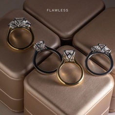 three wedding rings sitting on top of a brown suitcase next to two other pieces of jewelry