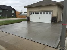 a house with a driveway in front of it and two garages on the other side