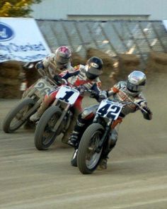 two motorcyclists are racing on the dirt track