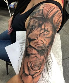 a woman with a lion and rose tattoo on her arm