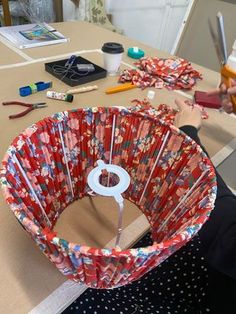 a woman sitting at a table working on crafts