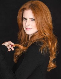 a woman with long red hair posing for a photo