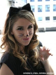 a woman with cat makeup on her face next to a black marker and a white background