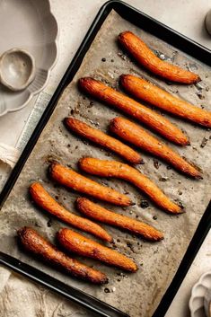 cooked carrots on a baking sheet ready to go into the oven for roasting