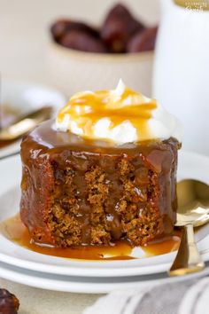 a piece of cake on a plate with caramel sauce and whipped cream