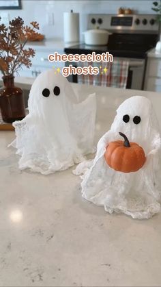 two plastic ghost figurines sitting on top of a counter