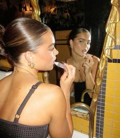 a woman brushing her teeth in front of a mirror