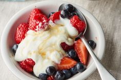 two bowls filled with fruit and yogurt on top of a table next to a blue towel