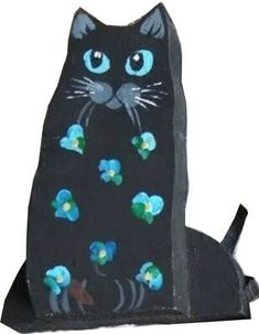 a black cat with blue eyes and flowers painted on it