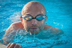 a man wearing goggles swimming in a pool