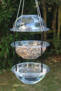 three tiered bird feeder hanging from a tree