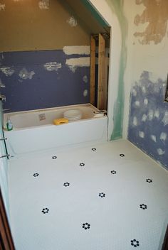 the bathroom is being remodeled with new flooring and wallpaper on the other side