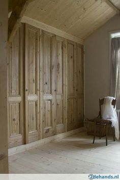 an empty room with wooden walls and doors