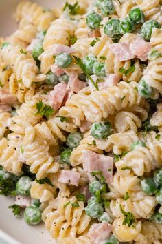 pasta salad with peas and ham in a white bowl