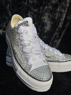 These beauties are great for weddings, birthdays, proms, sneaker balls, concert's, Quinceañera's, or any time you want to add a little Sparkle to your day! Purchasing this listing includes the LOW-TOP Converse All Star Platform shoes, original shoelaces and satin shoelaces. High Quality rhinestones will be used and you will need to notate the colors you are wanting. STYLE:*Bling Mix: This is a FULLY COVERED shoe, embellished with a mixture of different size Rhinestones covering all the canvas parts and the toes. CUSTOMIZATION: In the personalization section please provide me with #1) your need by date, #2) Color Selection, and #3) Sizing. Your “need by date” is only used as a reference and will require a RUSH Fee if less than 4 weeks. DO NOT put the date of the event/party as a need by dat Silver Sneakers For Wedding With Round Toe, Customizable White Sneakers For Party, Silver Lace-up Sneakers For Wedding, White Party Sneakers With Rhinestones, White Bling Sneakers For Party, Elegant Party Sneakers With Bling, White Rhinestone Party Sneakers, Party Sneakers With Bling, Satin Shoelaces