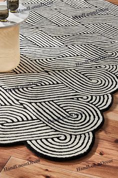 a black and white rug on the floor next to a table with two bottles in it