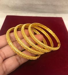 Christmas Gift, Holiday Gift,  24k gold plated Bangles, Indian Bridal Bangles, Handmade Bracelet for Women Gold Bangles for Women - Indian Bridal Bangles - Handmade Bracelet These stylish bangles feature a classic bangle design and are available in gold color. ▶ BEAUTIFUL HINGED GOLD BRACELET ▶ HIGED TO OPEN WIDE----- STAYS SECURELY SHUT -----  LIFT TAB SIDE TO OPEN Material: High quality 24k gold plated bangles ( Not solid gold) Diameter: 2.36 inches Can open Lead & Nickel free Tarnish resistan Gold Openable Round Bangle, Gold Plated Bangle For Puja, Gold Round Jewelry For Puja, Gold Plated Temple Jewelry Bangle, Gold Plated Openable Gold Bracelets, Round Gold Jewelry For Puja, Gold Temple Jewelry Bracelets, Intricate Design Gold Bracelet For Festivals, Yellow Bracelets With Intricate Design For Festivals